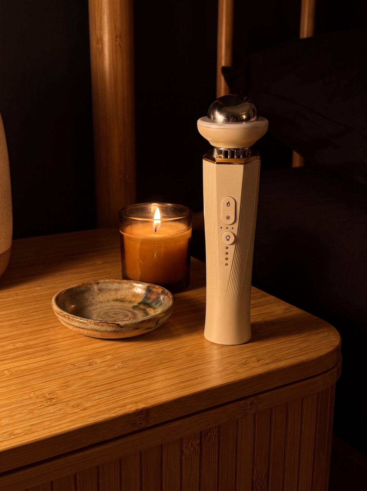 The depuffing wand resting on a nightstand beside skincare products